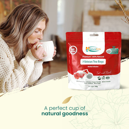 Woman drinking hibiscus tea with a package of Natural Evity Hibiscus Tea Bags in the foreground.